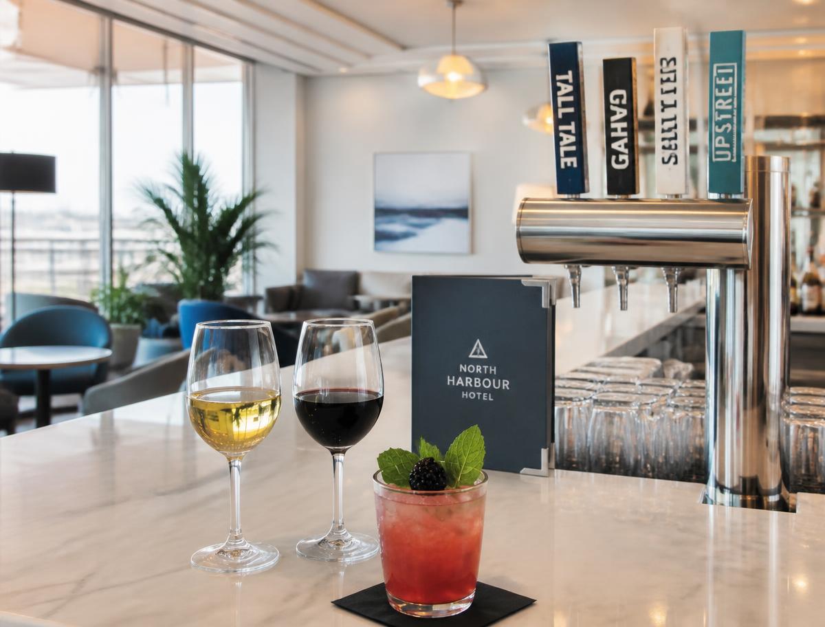Wine, a cocktail and craft beer taps on the bright bar counter at Perfecto Lounge